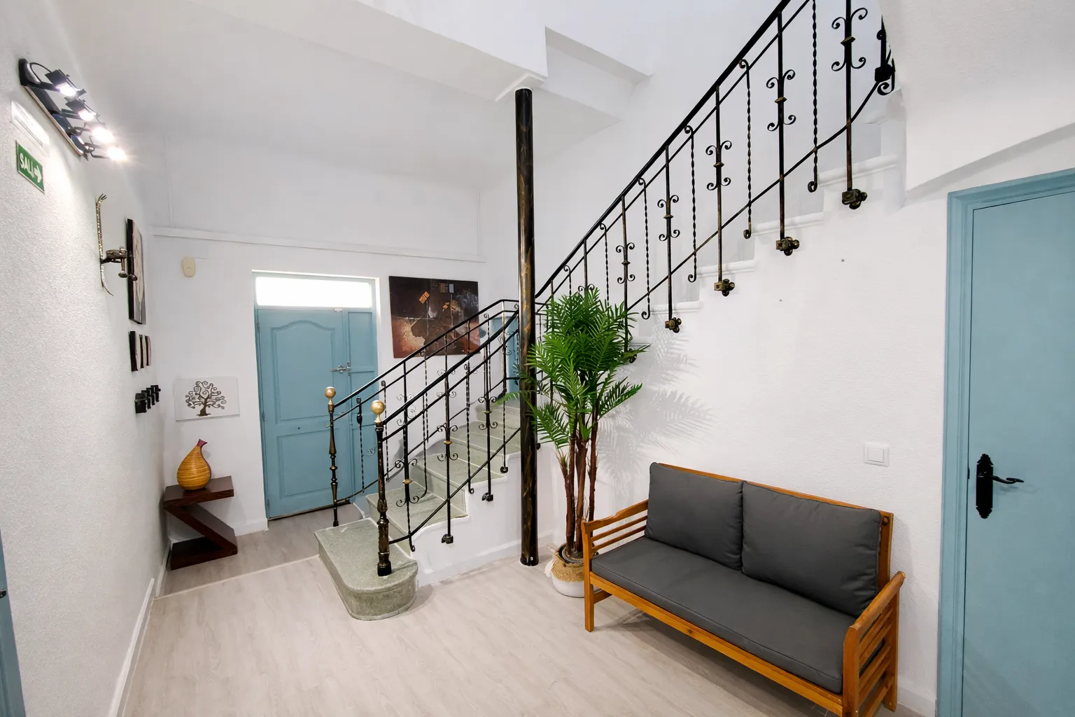 Zona de acceso de la casa con escalera y puertas en azul