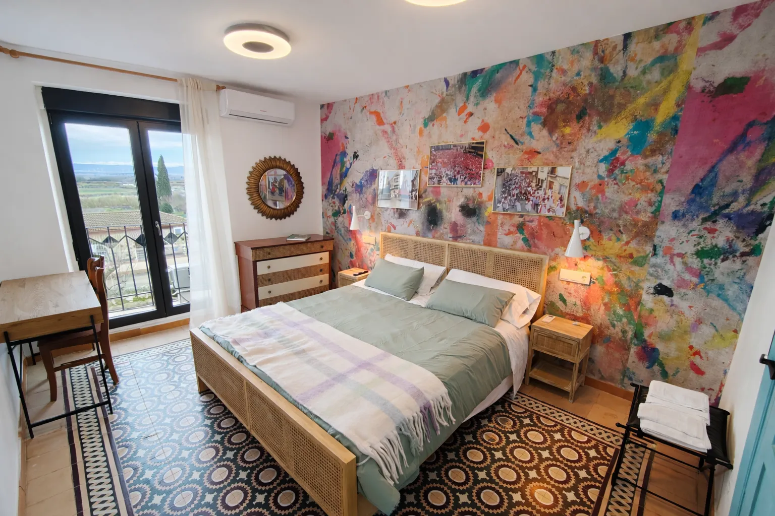 Habitación Chupinazo con mural de color, escritorio y salida al balcón