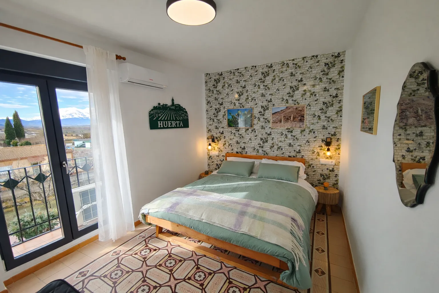 Habitación Huerta con ropa de cama verde y vistas al Moncayo desde el balcón