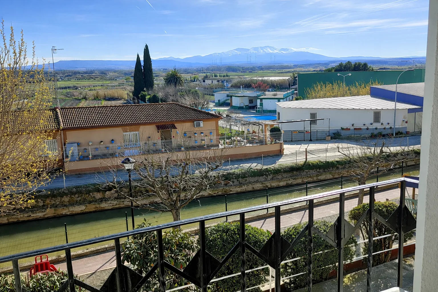 El Moncayo nevado visto desde un balcón de la casa, con la acequia en primer plano